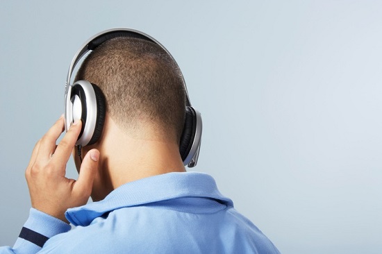Teenage boy listening to music through headphones