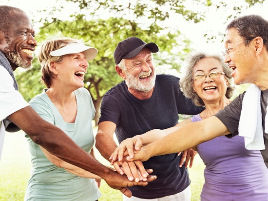 Group of older people smiling in a huddle with active gear