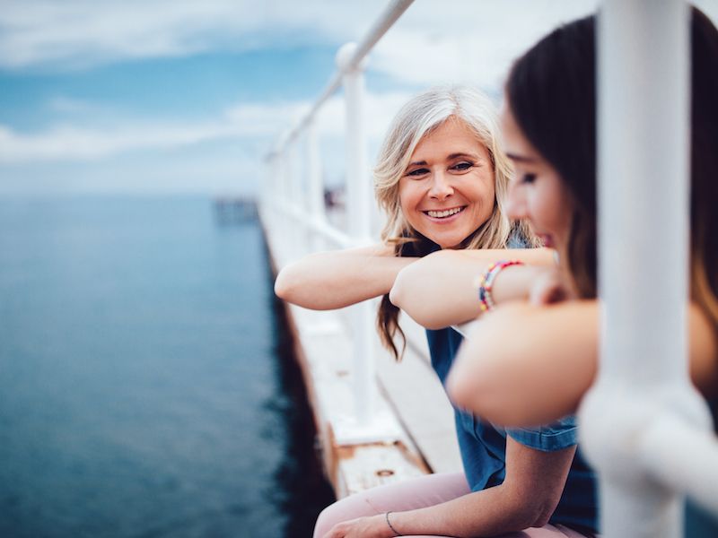 Woman talking with her granddaughter at a pier now that she is not suffering from high-frequency hearing loss.