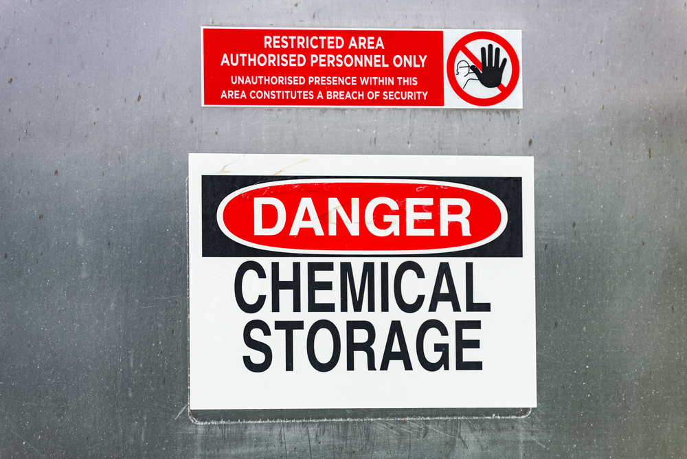 Danger warning sign for chemical storage in restricted area.
