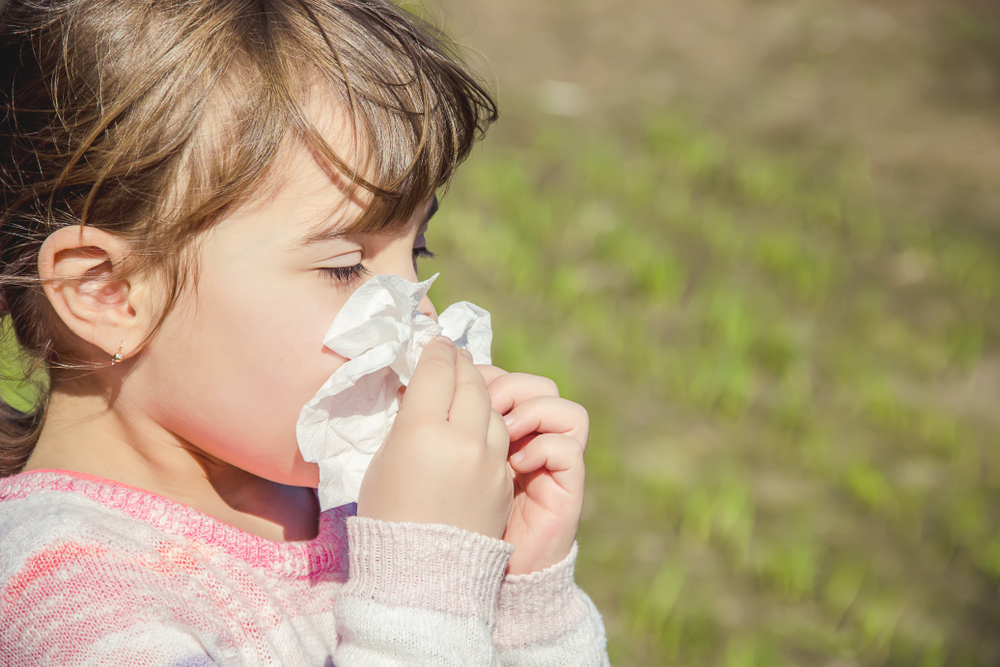 Female child with seasonal allergies outside.