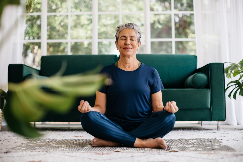 woman meditating in lotus position at home.