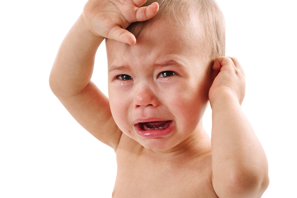 upset baby crying due to ear pain.