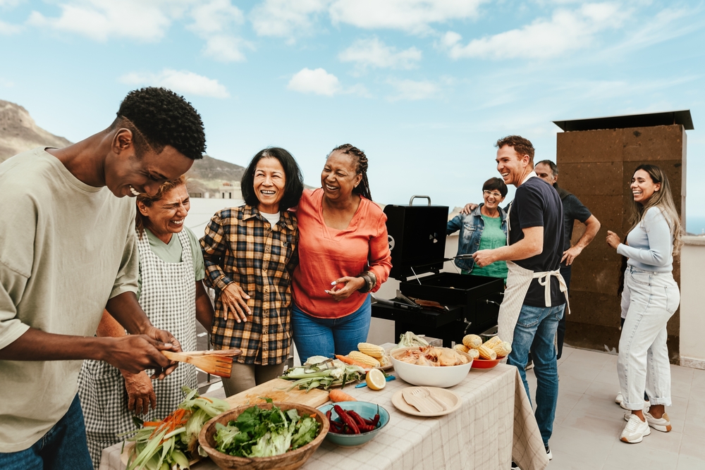 Happy multigenerational people having fun doing barbecue grill at house rooftop.