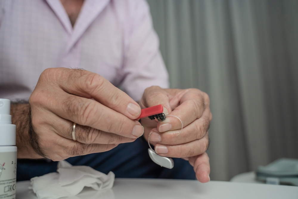 man cleaning his hearing aid.