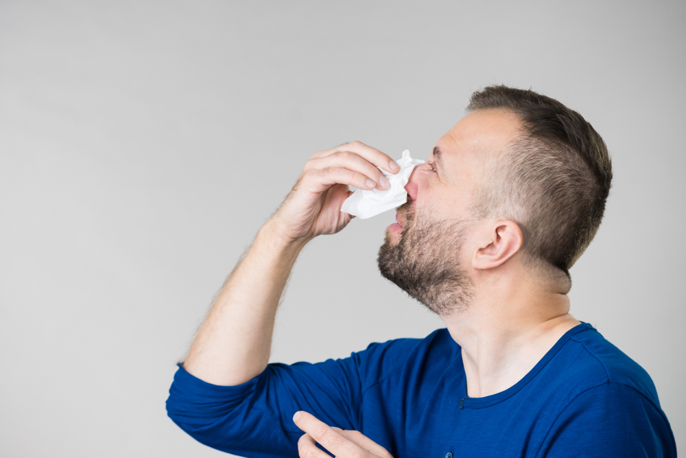 Man blowing his nose.