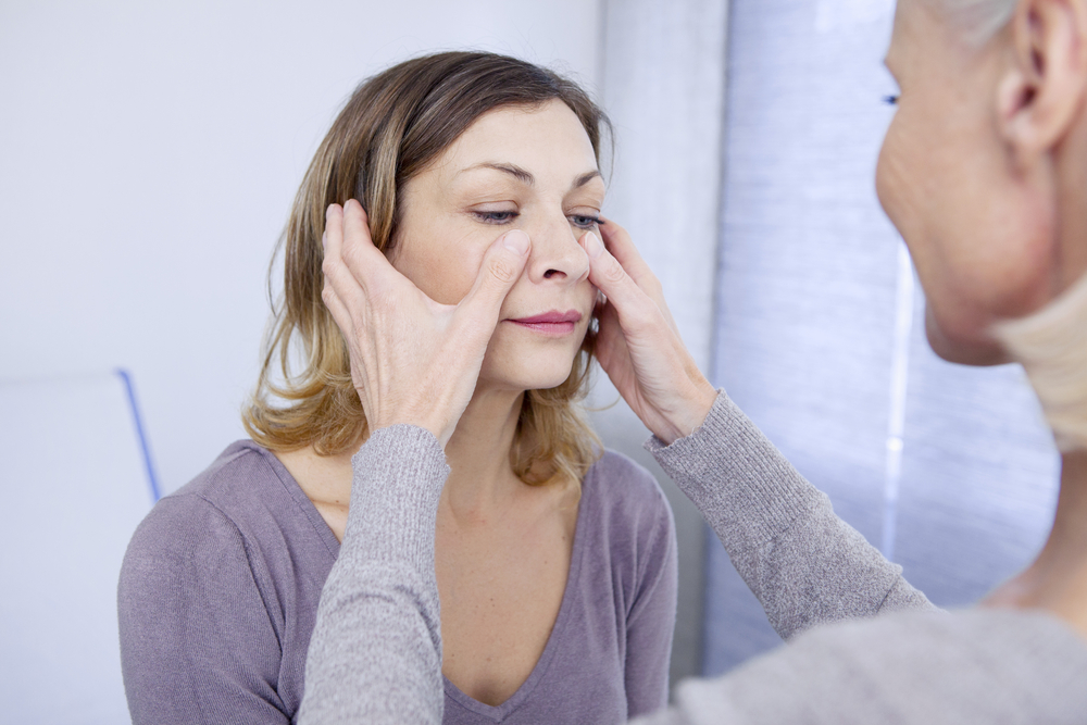 Woman patient getting sinuses checked.