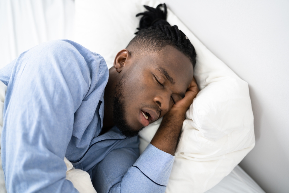 Man sleeping and snoring in bed.