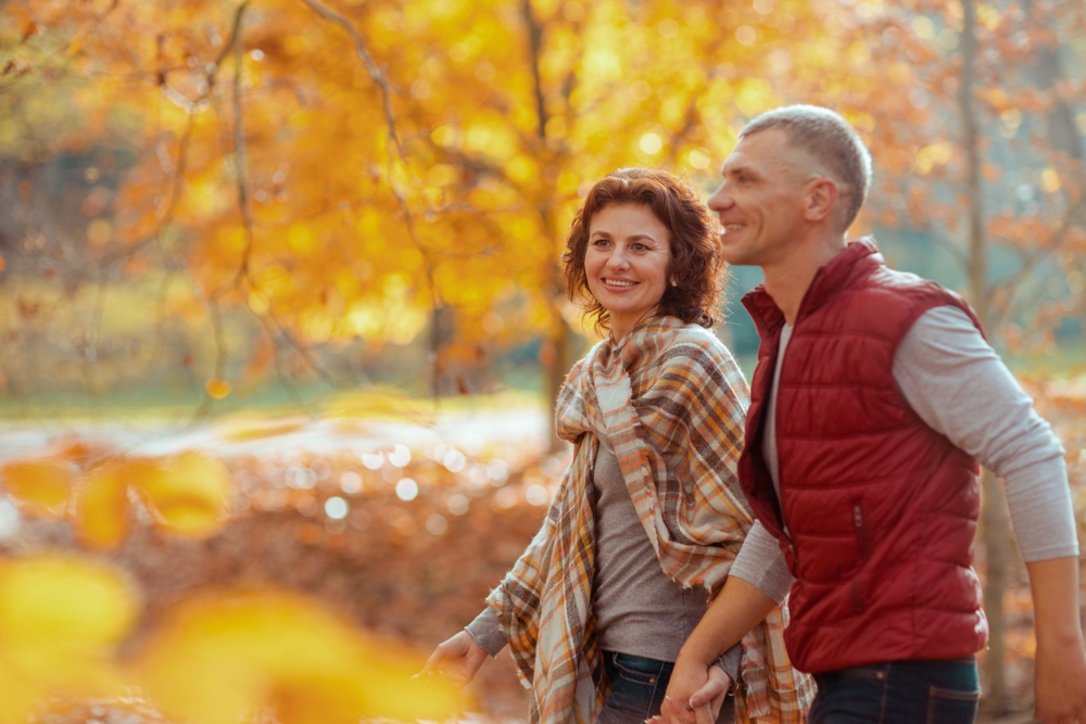 smiling couple in the park walking in the fall.