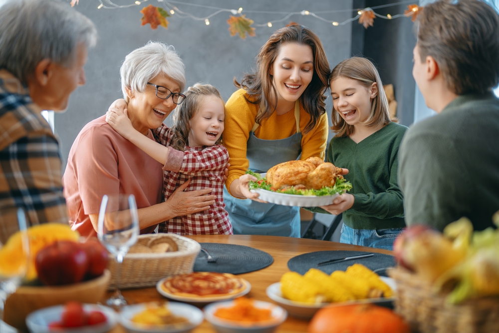 Happy family sitting at the table and celebrating Thanksgiving.