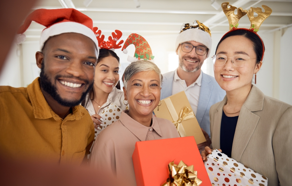 group of co-workers smiling at office holiday party.