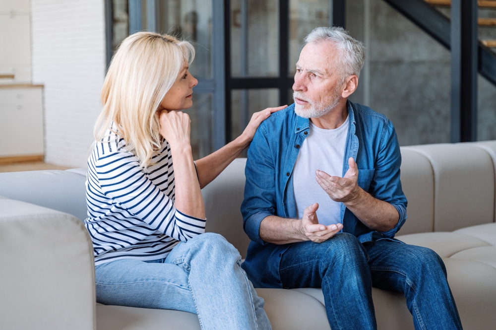 couple sitting on couch talking.