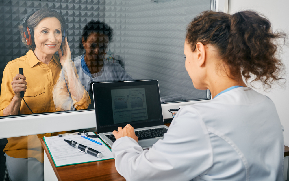 Mature woman getting a hearing test at audiology center.