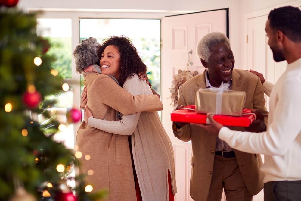 Adult children getting their senior parents as they arrive with Christmas presents.