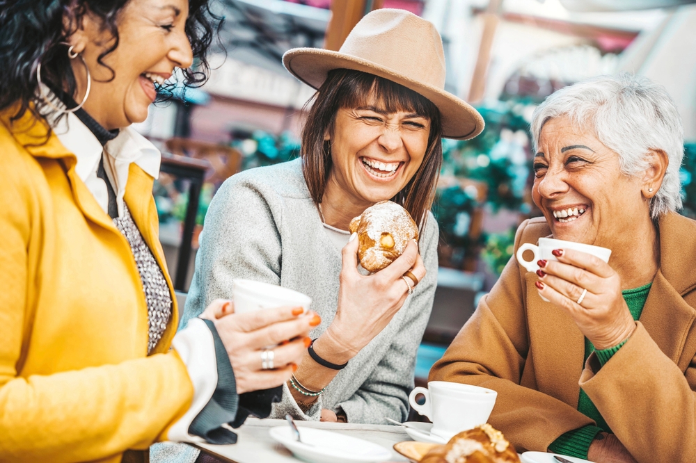 Three women enjoying breakfast and drinking coffee.