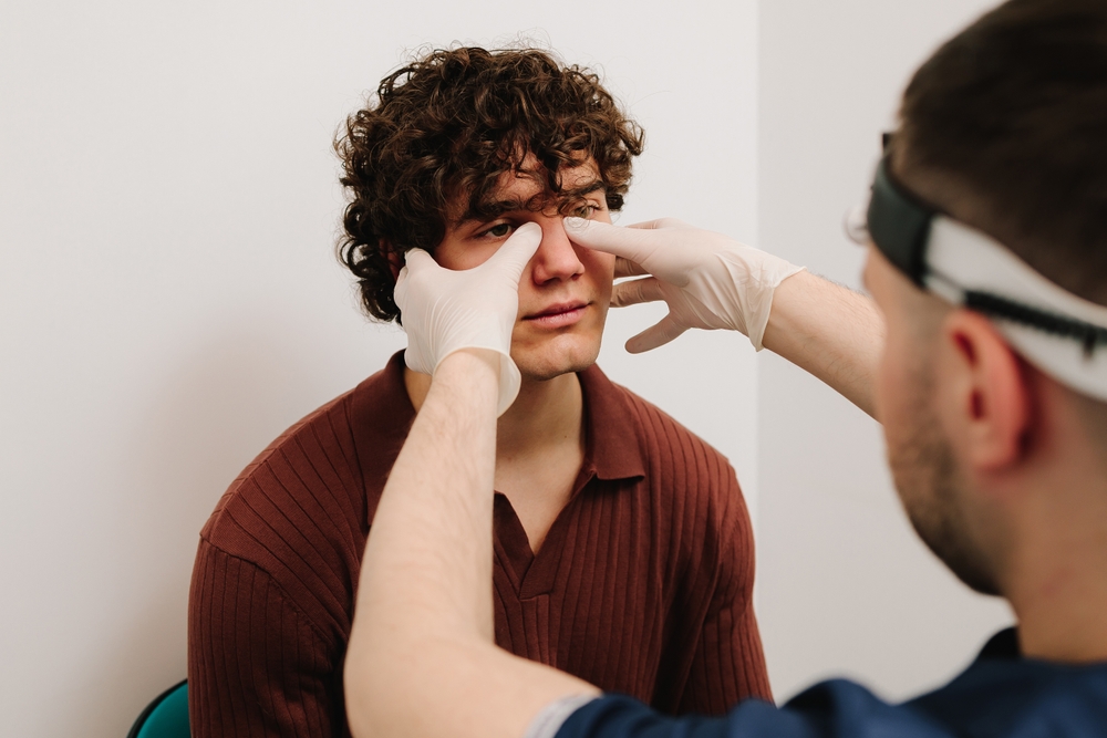 ENT doctor examine nose of male patient.