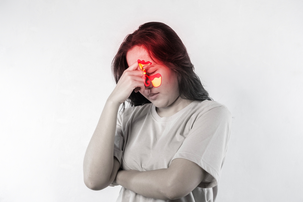 Female face with inflammation of mucous membrane of paranasal and frontal sinuses.