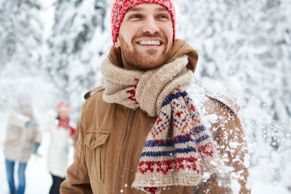 Happy guy in winter wear outside with his friends.