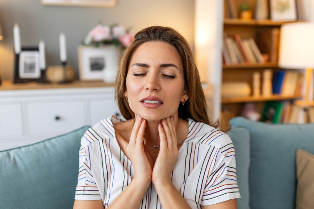 woman suffering from swollen tonsils.