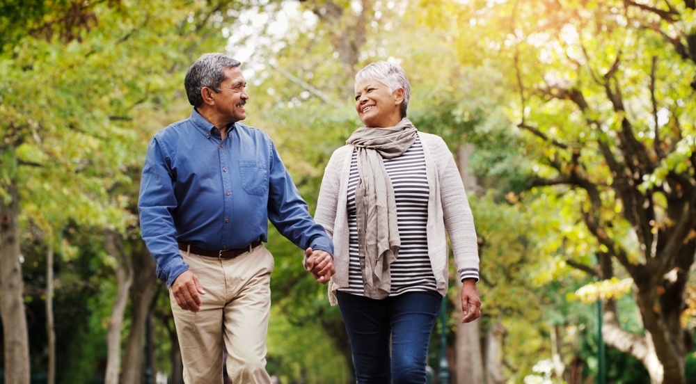 man and woman walking outside, holding hands.