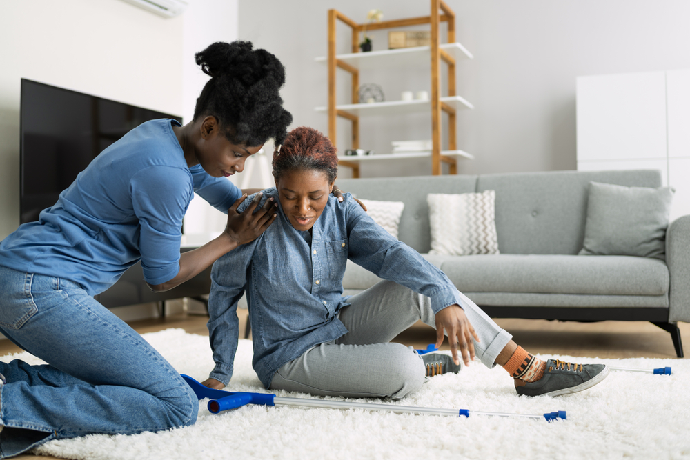 daughter helping middle aged mother after fall.