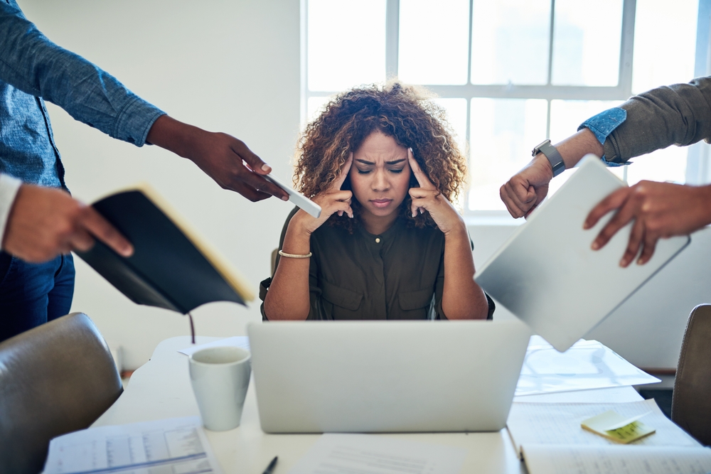 Shot of a stressed out young woman working in a demanding career.